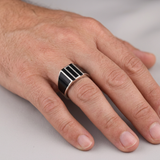 Hand wearing the black-and-silver ring
