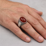 Hand wearing the red-stone silver ring
