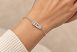 925 sterling silver bracelet with elongated centerpiece and three circular details worn on a hand